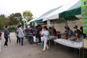 ぬか釜で炊いた新米おにぎりと南魚沼産食材のけんちん汁を受け取る一般参加者たち