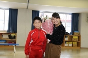 花束贈呈した児童とTSUNEIさん