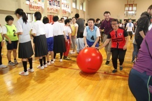 2人で協力してボールを運ぶ総合支援学校の生徒と国際大学の学生