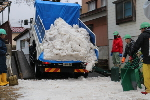 トラックで園庭に雪を運び込む地元の建設業者たち