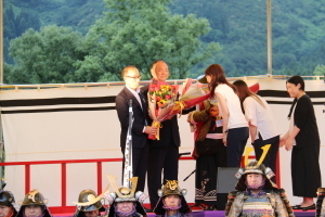 米沢市、米沢藩古式砲術保存会の歓迎セレモニーで花束を贈っている様子