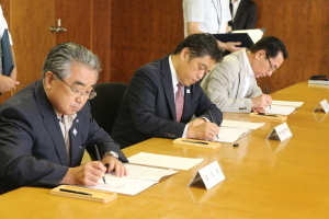 協定書に署名をする湯沢町町長と林市長と魚沼市市長