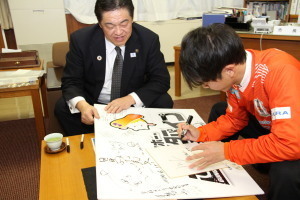 サインボードにサインをする吉田選手