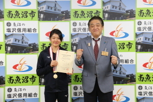 メダルと賞状を持つ小林萌子さんと市長の記念写真