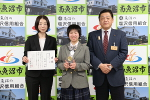 受賞のトロフィーと賞状を持ち、集合写真を撮る林市長と石田のあさんとのあさんのお母さま