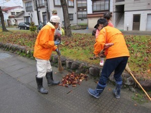 落ち葉を箒で掃いている様子
