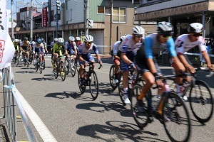 商店街を自転車で駆け抜ける選手たち
