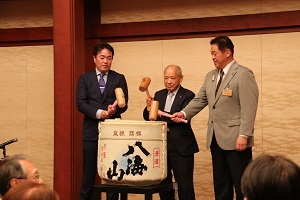 林市長、塩谷議長、関西新潟県人会長の小谷野さんの三人による鏡開きをする様子