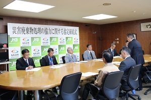 新潟県産業資源循環協会三魚沼支部南魚沼分会の関理事があいさつする様子