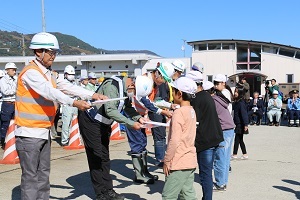 メッセージを添えた鍵を渡す石打小学校の児童たち