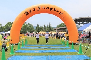 手をつないでゴールするランナー