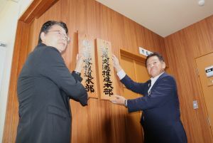 観光戦略推進本部の看板をかける林市長と、次世代交通推進本部の看板をかける小髙副市長