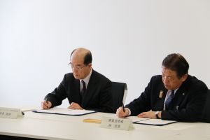 署名をする今泉社長と林市長