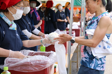 大盛りのご飯を受け取る女性
