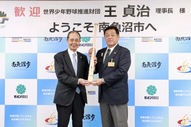 王さんから林市長にサイン入りバットが授与される様子