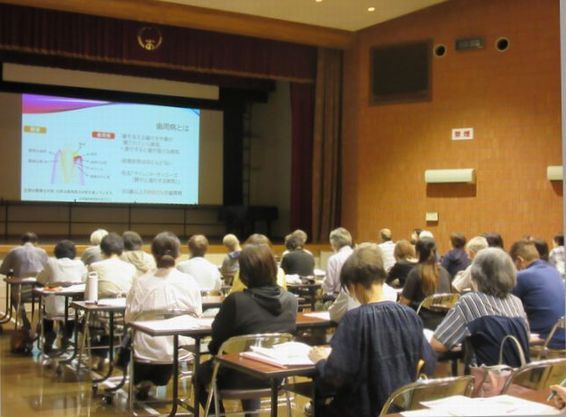 第2回南魚沼市健康推進員研修会の様子です。前方に投影されたスライド資料をもとに、歯科衛生士がお話しています。