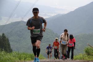 城内地区を背景に坂道を上る参加たち