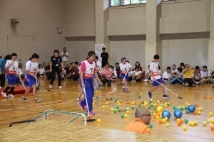 フロアブラシでボールをゴールに入れる競技を行う総合支援学校の女子生徒