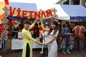 民族衣装をまとったベトナムの学生と料理ブース