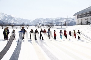 越後上布を使った雪さらしをする参加者とその保護者たち