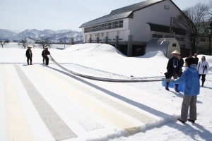 越後上布を使った雪さらしをする参加者たち