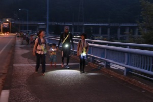 ライトをつけて多聞橋を渡る参加者