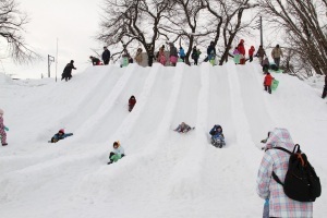 雪のすべり台で遊ぶ子どもたち