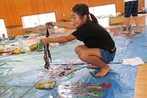 絵の具で染まった和紙をちぎって、いろいろな形を作る児童