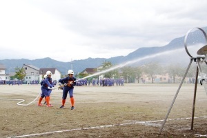 ポンプ操法で放水を行う女性消防団員