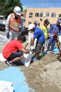 土のうづくりを体験する児童たち