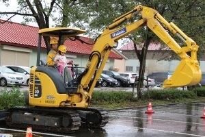 小型の重機の試乗体験をする子ども