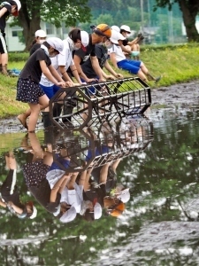 田植え定規で印をつける児童たち