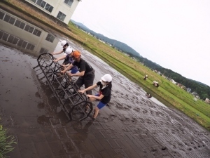 田植え定規で印をつける児童たち2