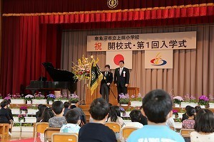 校旗をもつ校長と市長