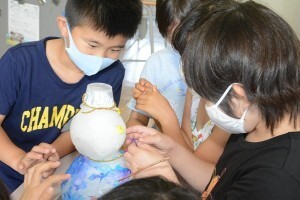 雪に飾りつけする江戸川区の小学生たち