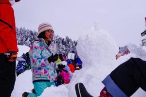 笑顔で雪像を作る児童たち