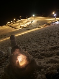 夜の五日町スキー場。児童が作成した雪灯籠に火が灯されている
