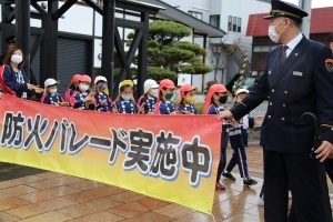 牧之通りを歩く園児たちと防火パレード実施中の横断幕