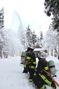 雪のなか放水を行う消防署員