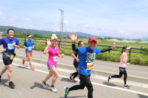 ハーフマラソンのコースを笑顔で走る選手たち