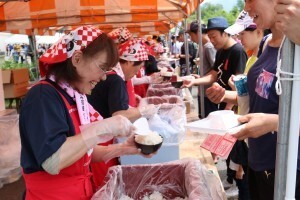 炊き立てのご飯を受け取る選手たち