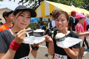 ご飯とともに地元のグルメを楽しむ参加者