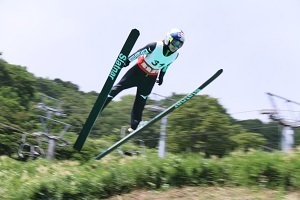 空に向かって大きく飛ぶ選手