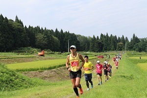 田んぼの中を走る選手たち
