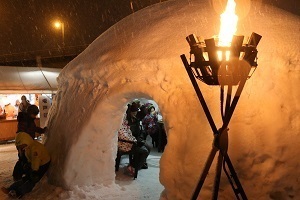 ほんやら洞(かまくら)のなかで飲食する来場者たち