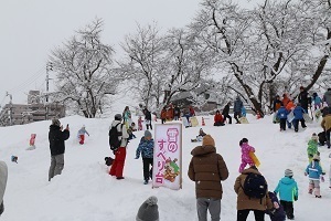 雪の滑り台で遊ぶ来場者たち