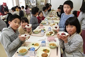 梅干が乗ったご飯を手にもつ児童たち