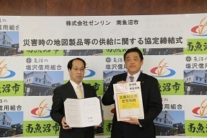 協定書をもつ株式会社ゼンリンの新潟営業所長とゼンリンから提供された地図をもつ林市長