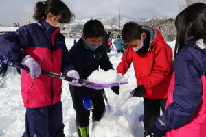 雪を容器につめる子どもたち