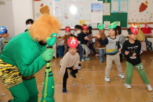 緑鬼と新聞紙で作った豆を投げる子どもたち